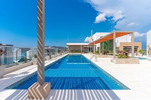 A rooftop swimming pool with clear blue tiles, surrounded by modern architecture and a view of the cityscape. - Salguero Suites by RV Stays (Santa Marta)