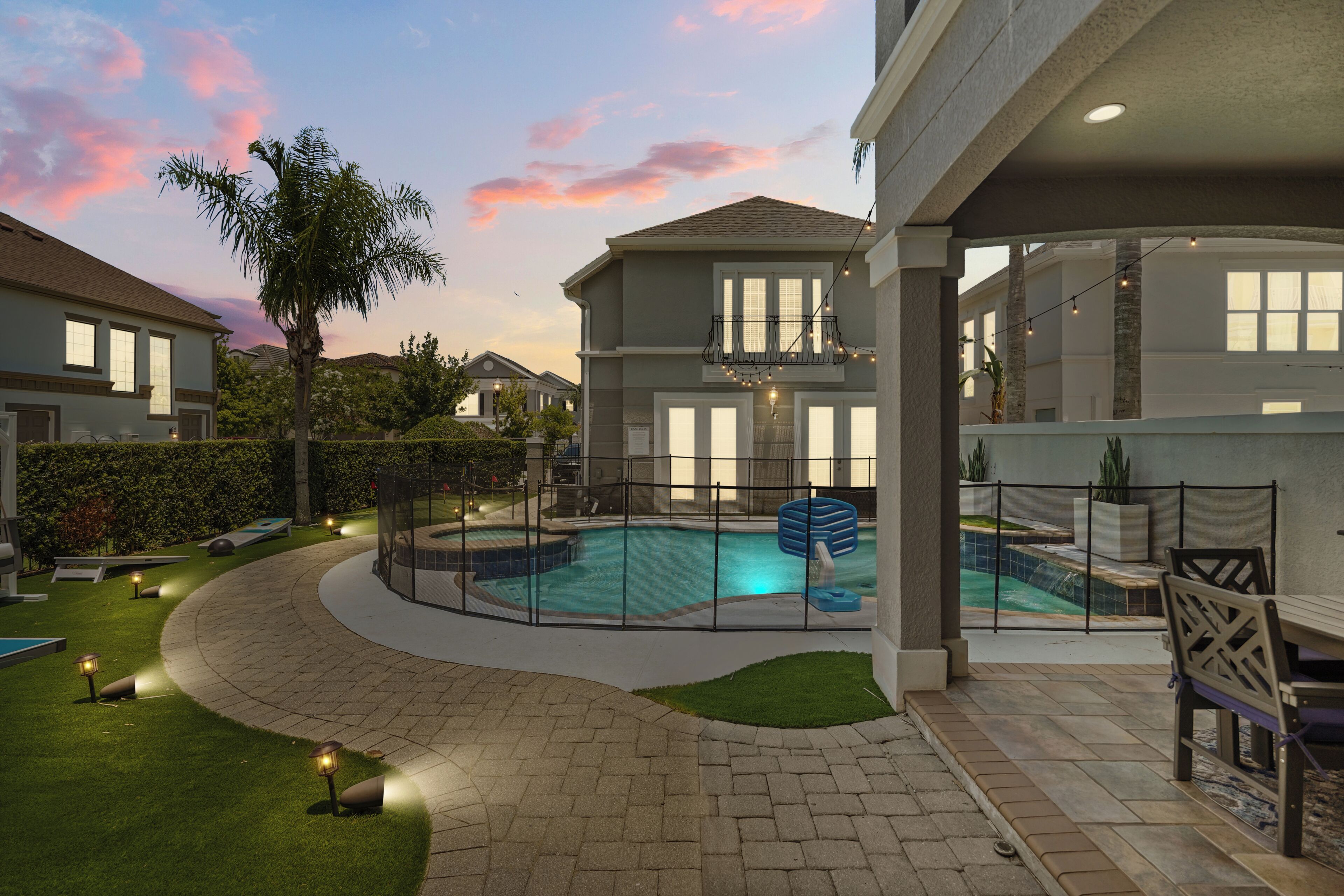 A residential area with a swimming pool, a covered patio, and a landscaped garden.