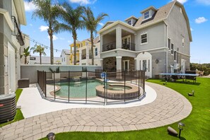 Ein Wohnhaus mit Schwimmbad, überdachter Terrasse und gepflegtem Rasen.