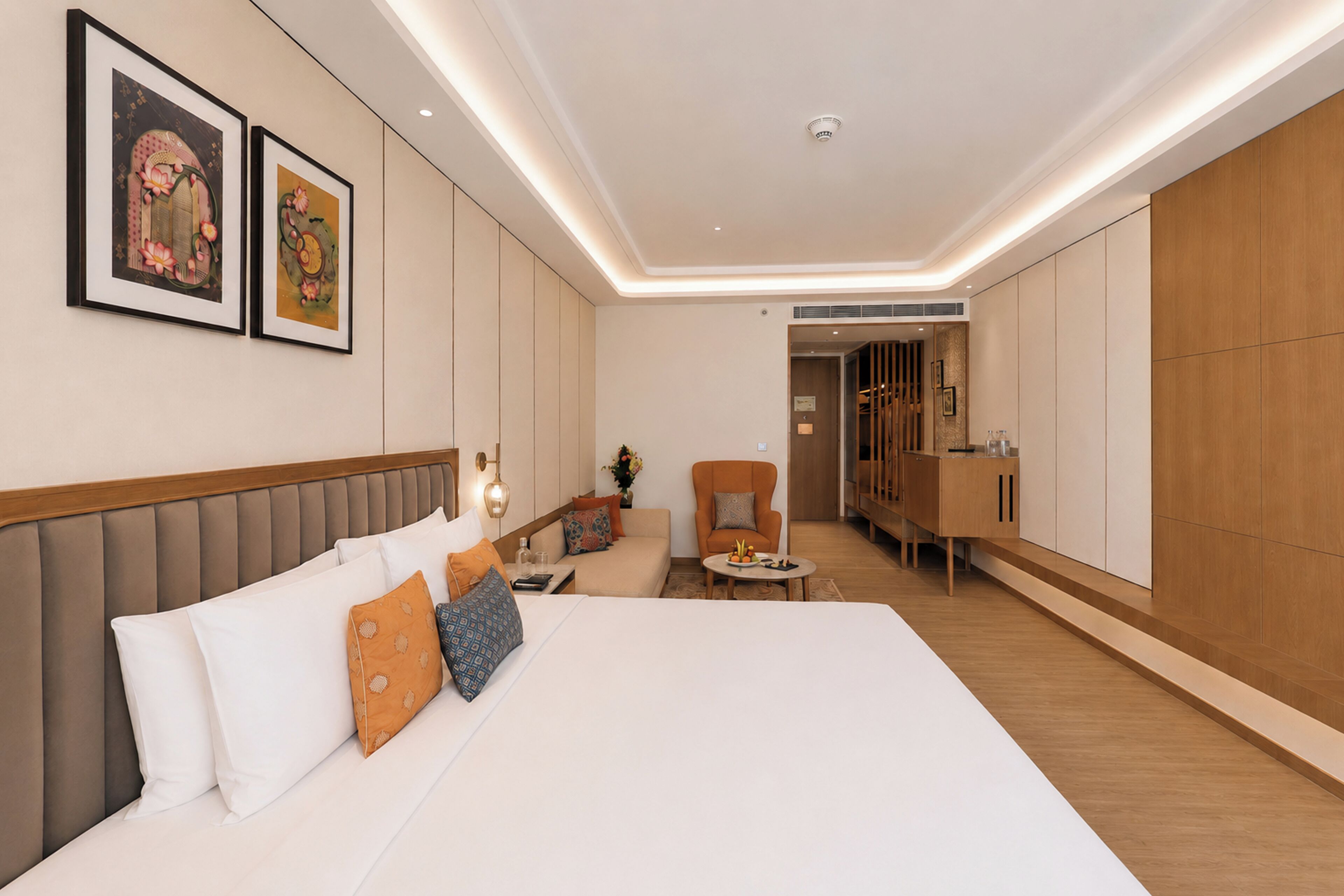 Habitación de hotel moderna con una cama grande, zona de estar y un armario.