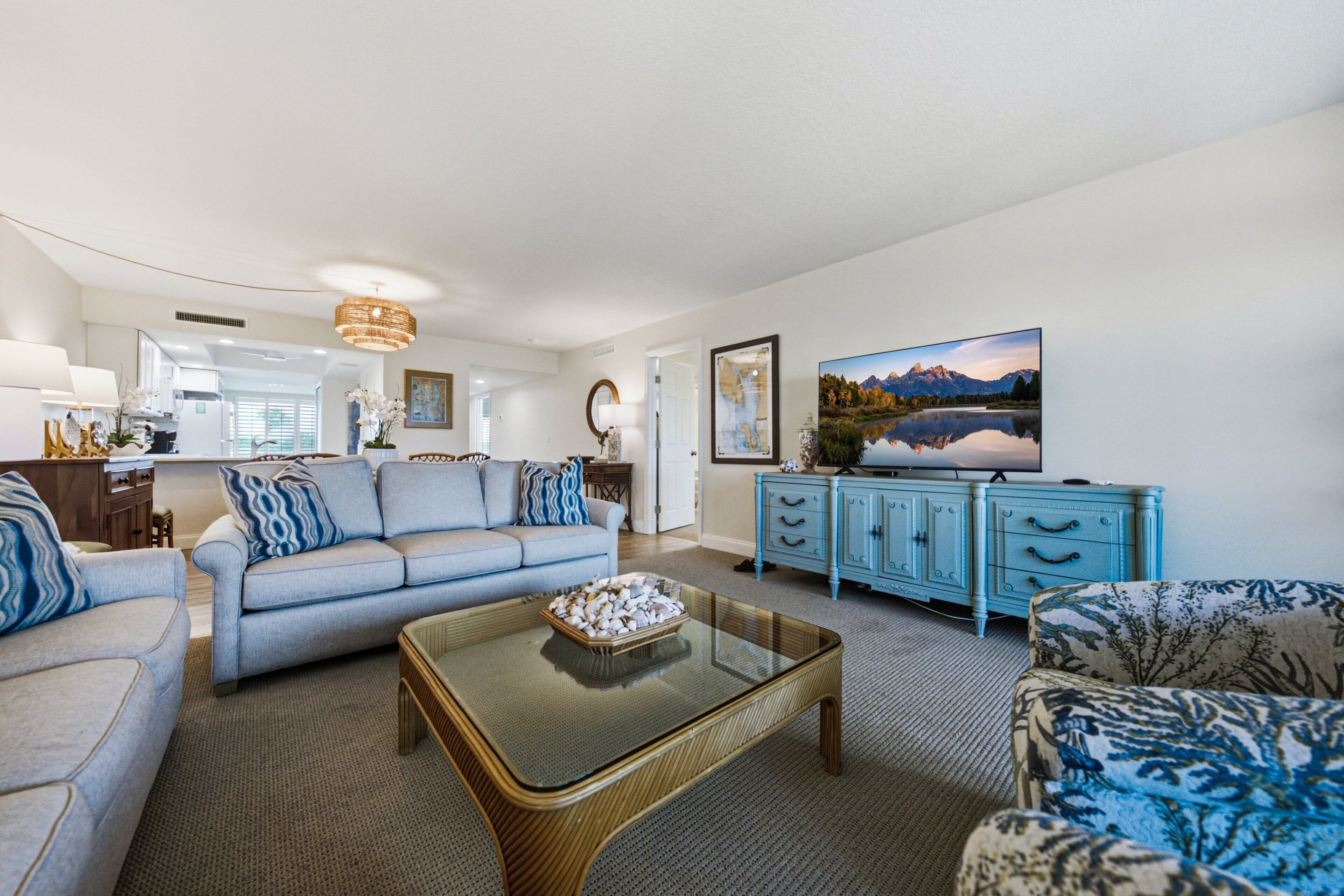 A living room with a sofa, a coffee table, a television, and a cabinet.