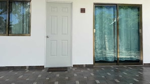A building with a white door, two windows, and a glass door.