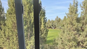 A window with a view of a forested area and a grassy field. - Cozy 2-bedroom townhome in Eagle Crest with AC and gym access (Redmond)
