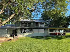 A two-story house with a front porch, a garage, and a small attached structure with outdoor seating.