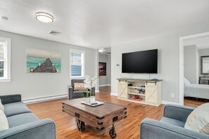A living room with a flat-screen TV, a coffee table, and a sofa.
