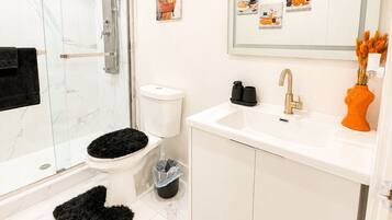 Een douche, handdoeken, zeep, toiletpapier