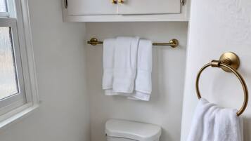 Een haardroger, handdoeken, zeep, toiletpapier