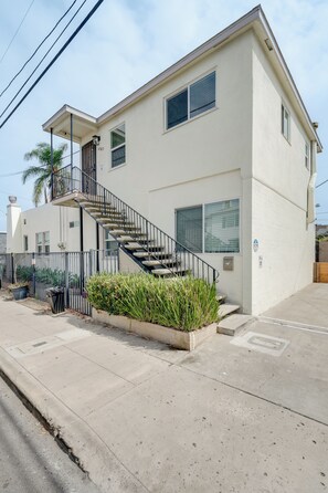 A two-story building with a balcony, a staircase, and a small garden area. - Luxury San Diego 1BR with Premium Conveniences (San Diego)