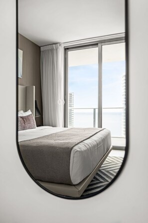 Une chambre d’hôtel avec un grand lit, une vue sur la ville et un balcon.