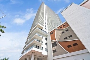Un immeuble moderne de grande hauteur, doté de nombreux balcons et d’une architecture originale.