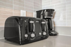 Ein schwarzes Toaster und eine schwarze Kaffeemaschine auf einer Küchenarbeitsplatte.