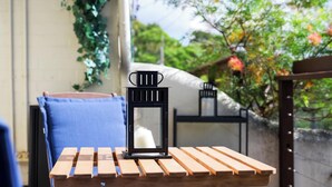 A table with a black lantern, a blue cushion, and wooden slats. - KozyGuru | Glebe | Chic Stay - Steps to Light Rail (Glebe)