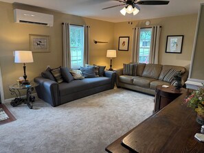A living room with two sofas, a coffee table, a lamp, and a ceiling fan.