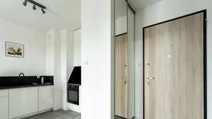 Eine moderne Küche mit weißen Schränken, einer schwarzen Arbeitsplatte und einem eingebauten Backofen.