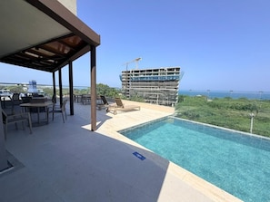 A pool area with a view of a building under construction and a clear sky. - Santa Marta Apartment with Ocean Views (Santa Marta)