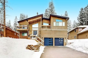 A two-story wooden house with a garage, a balcony, and a stone staircase. - New 2023 Built, 5-bedroom Tahoe Donner house in Truckee with AC + Meadow Views (Truckee)
