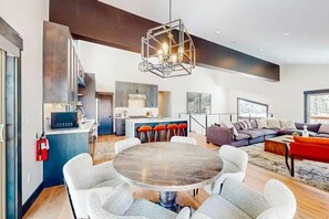 A modern living space with a dining area, kitchen, and seating area. - New 2023 Built, 5-bedroom Tahoe Donner house in Truckee with AC + Meadow Views (Truckee)
