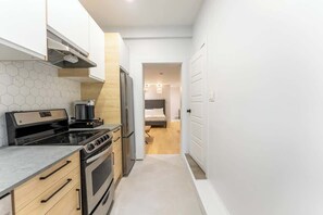 Una cocina estrecha con estufa, horno y microondas.