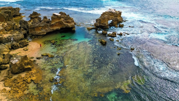 Un paysage côtier caractérisé par des formations rocheuses et des eaux cristallines.