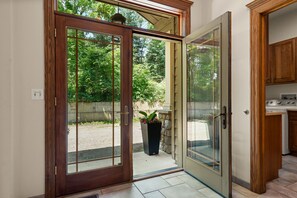 Una puerta corrediza de vidrio que da a un patio con un muro de piedra y una planta en maceta.