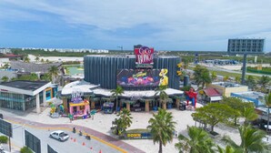 Un grande complesso di intrattenimento con un evidente cartello 'Coco Bongo', un maxischermo e una statua di Spider-Man.