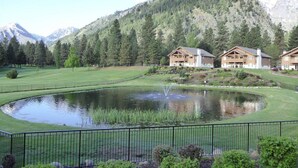 A residential area with a pond, a fence, and houses with a mountain backdrop. - Vacation Winter Getaways at Leavenworth (Leavenworth)