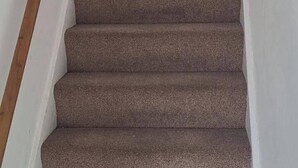 A carpeted staircase with wooden handrails, leading to an upper floor. - Birmingham Bliss Retreat (Birmingham)