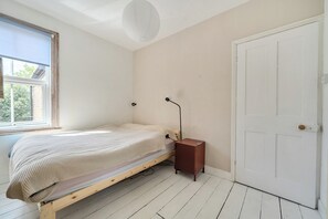 A room with a bed, a white door, and a window with blinds. - Victorian Terrace near Uni, sleeps 6, Garden (Reading)