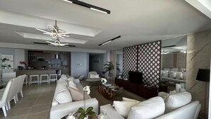 Un salon moderne avec un canapé, une table basse et un téléviseur.