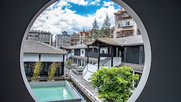 Una piscina al aire libre, sombrillas, sillones reclinables de piscina