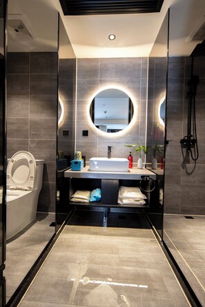 Un baño moderno con inodoro, lavabo y ducha.