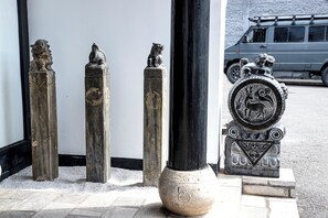 Cuatro estatuas de leones de piedra y una columna decorativa con un emblema circular.
