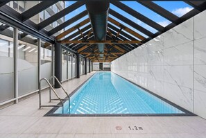 An indoor swimming pool with a skylight, clear ceiling, and tiled walls. - Triple Aspect Views - from the City to the Sea (Southbank)