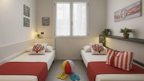 Habitación de hotel con dos camas, una ventana, un balón de playa y chanclas en el suelo.
