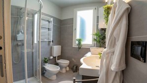 Un baño moderno con cabina de ducha de vidrio, inodoro, lavabo y bañera.