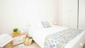 Un dormitorio con cama, mesita de noche y armario.