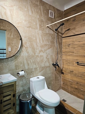 A modern bathroom with a toilet, sink, and shower.