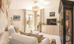 A modern living room with a sofa, a television, and a cabinet. - Holiday apartment mit Klimaanlage und Balkon (Imperia)