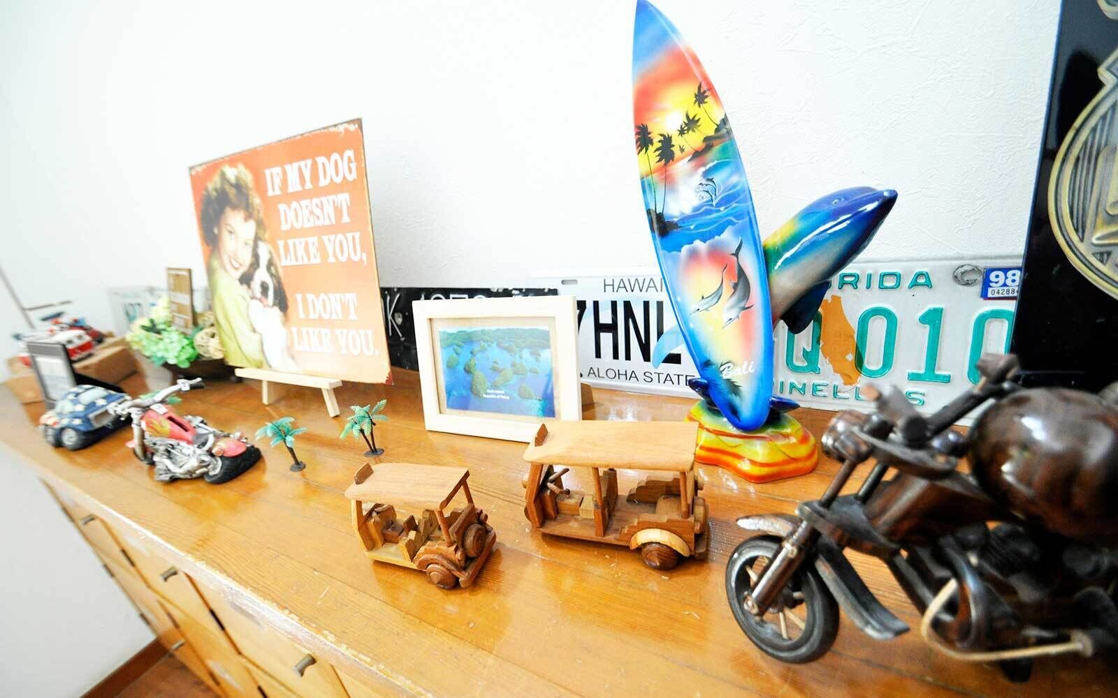 A wooden desk with various items including a surfboard, a motorcycle, and a sign with a dog.