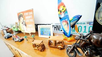 A wooden desk with various items including a surfboard, a motorcycle, and a sign with a dog.