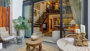 A modern interior with a staircase, seating area, and large windows. - Chic Nomada Loft with Infinity Pool Romantic Zone (Puerto Vallarta)