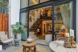 Ein modernes Interieur mit Treppe, Sitzgelegenheit und großen Fenstern.