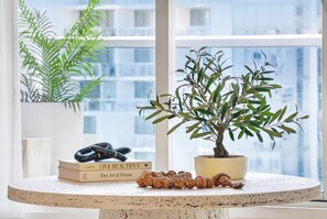 Ein runder Tisch mit einem Blumentopf, Büchern und einem dekorativen Gegenstand.