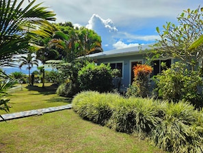 Ein Haus, umgeben von üppigem Grün und blauem Himmel.