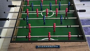 A foosball table with a wooden frame and a green playing surface. - Modern Miami Retreat w/ Games (Miami)
