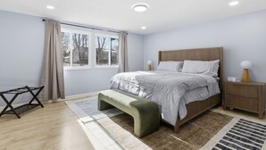 A bedroom with a bed, bedside table, bench, window, and a radiator. - Gorgeous 3-bedroom house with AC in pleasant Fishers (Fishers)