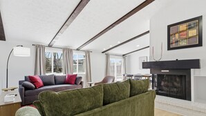 A living room with a sofa, a fireplace, a table, and a lamp. - Gorgeous 3-bedroom house with AC in pleasant Fishers (Fishers)