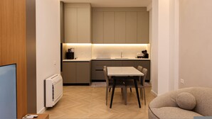 Una cocina moderna con comedor, horno integrado y televisor de pantalla plana.