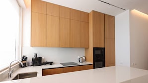 Una cucina moderna con mobili in legno, un piano di lavoro, un lavello e un forno integrato.