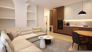 Un salon moderne comprenant un canapé, une table basse et un coin repas avec une table et des chaises.